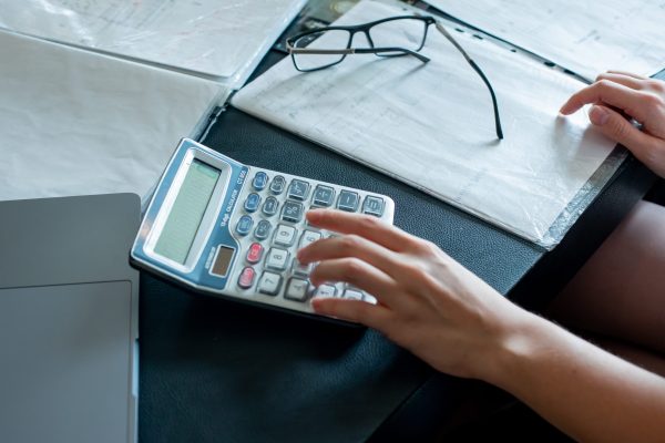 close-up view of female hands doing calculations and documents with glasses on office desk working process office concept close-up view of female hands doing calculations and documents with glasses on office desk working process office concept